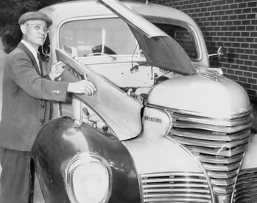 Mario Lobato opens hood of taxicab.