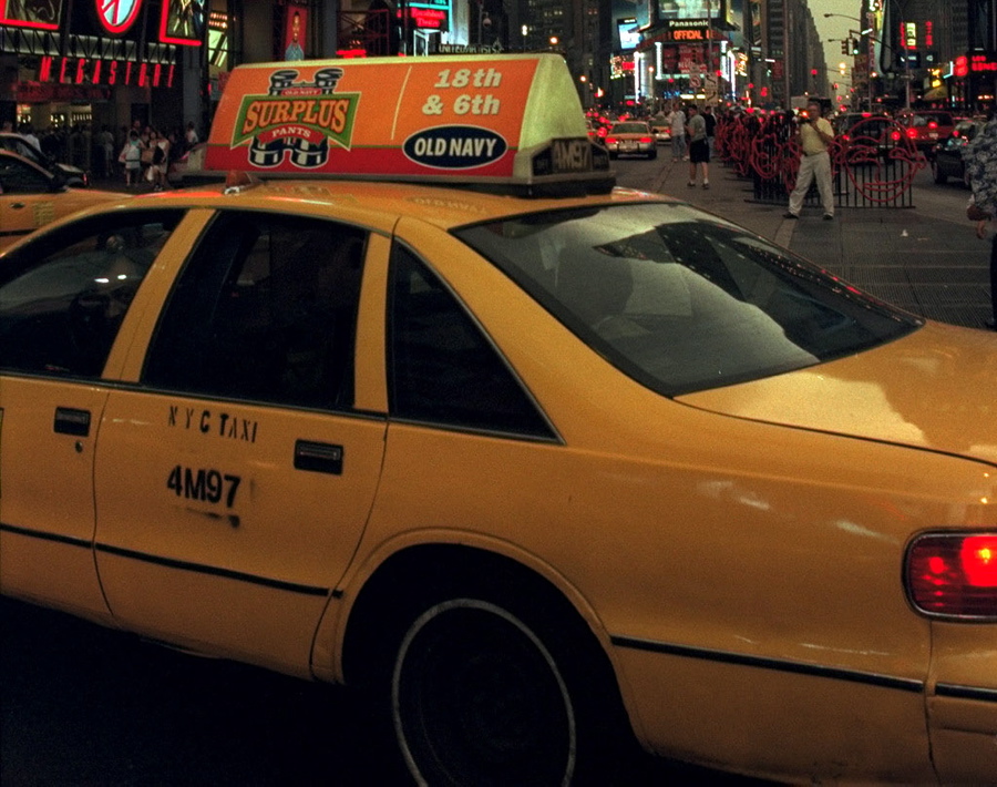 A taxi drives along Times Square.