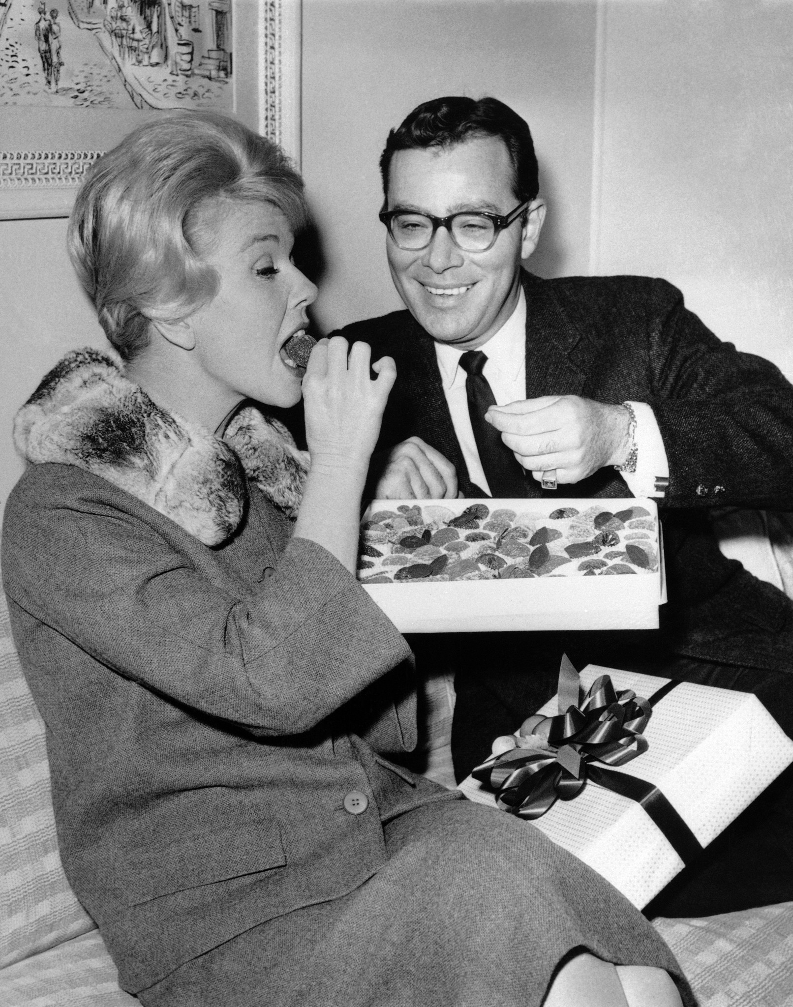 Producer Ross Hunter watches as Doris Day consumes his gift of candied fruit on May 11, 1960, in Los Angeles.