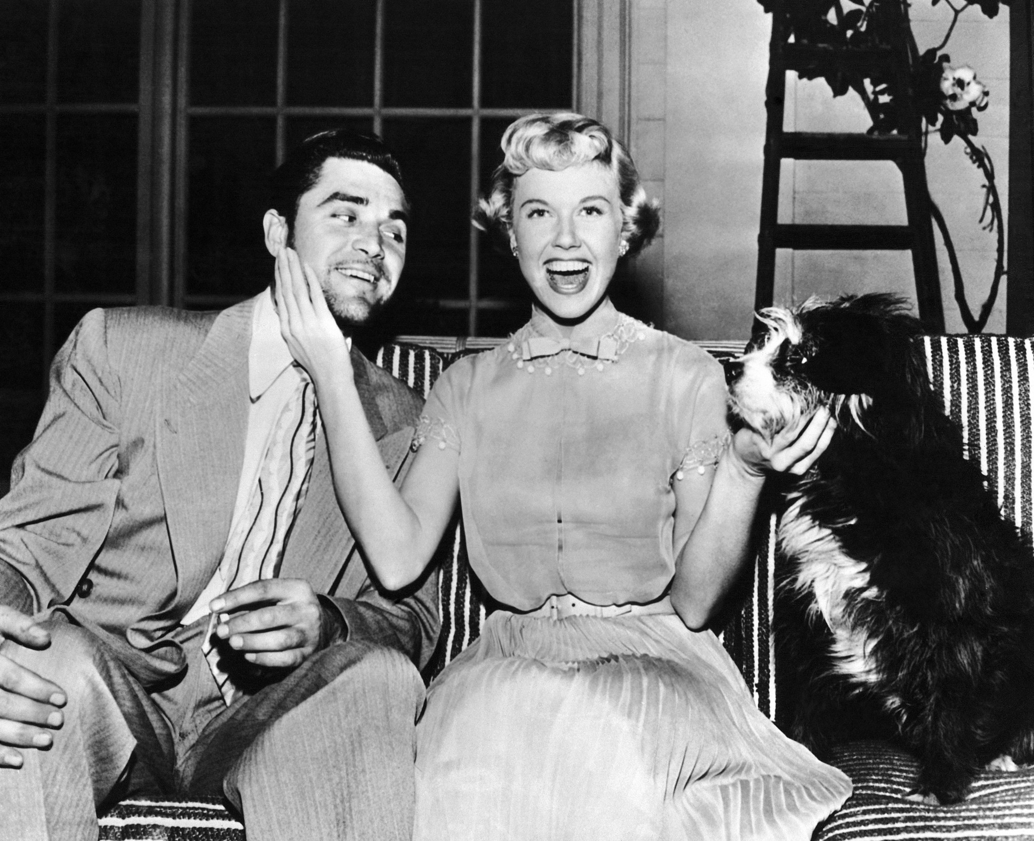 Screen actress Doris Day compares the whiskers sported by actor Steve Cochran, just back from a two-week vacation, with his pet dog named Tschaikowsky on May 2, 1950, in Los Angeles. Cochran visits Day on the set of 
